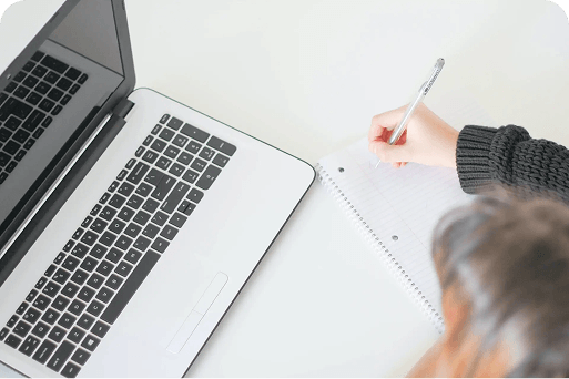 A person writing notes on a pad of paper